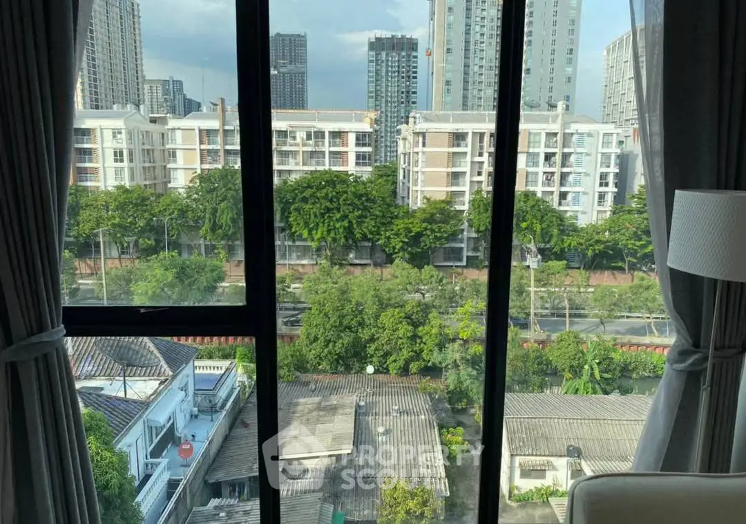 Stunning urban view from a high-rise apartment window, showcasing city skyline and lush greenery.