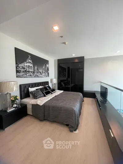 Modern bedroom with sleek black furniture and stylish decor in a contemporary apartment.
