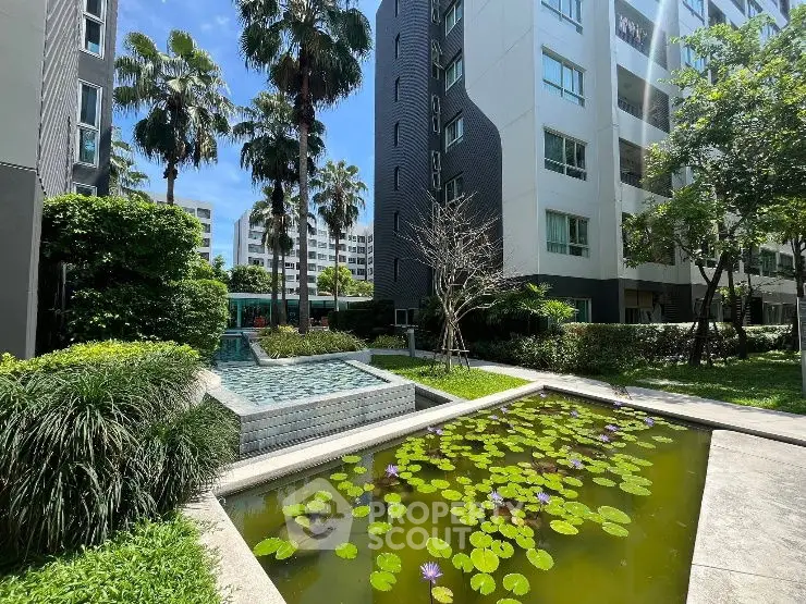 Modern apartment complex with lush garden and serene water feature