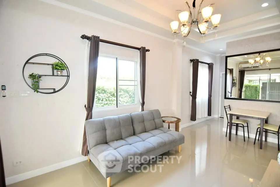 Modern living room with elegant chandelier and cozy gray sofa