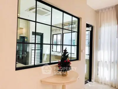 Bright interior with modern window design and festive decor, showcasing elegant living space.
