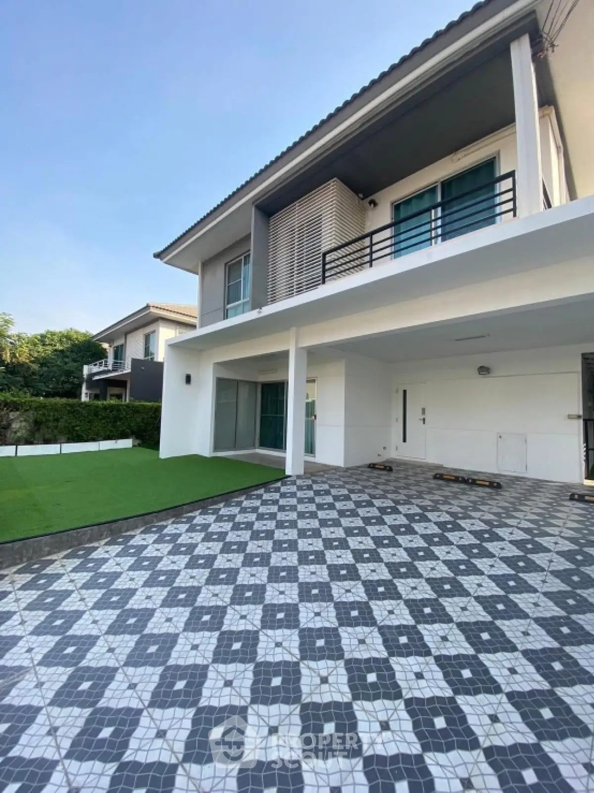 Modern two-story house with spacious driveway and green lawn in a serene neighborhood.