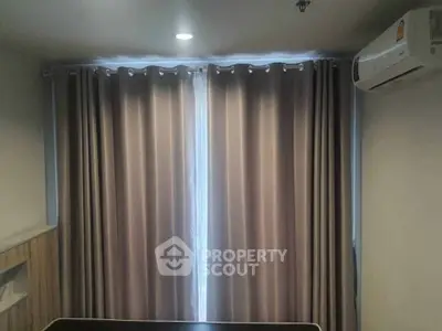 Cozy bedroom with elegant curtains and air conditioning unit, perfect for a comfortable living experience.