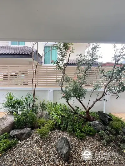 Charming garden view with lush greenery and modern fencing in a serene residential setting.