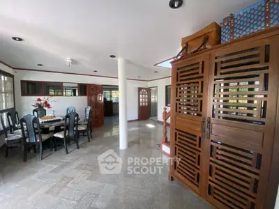 Spacious dining area with elegant wooden furniture and ample natural light.