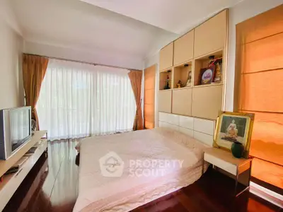 Spacious bedroom with elegant decor and large windows for natural light