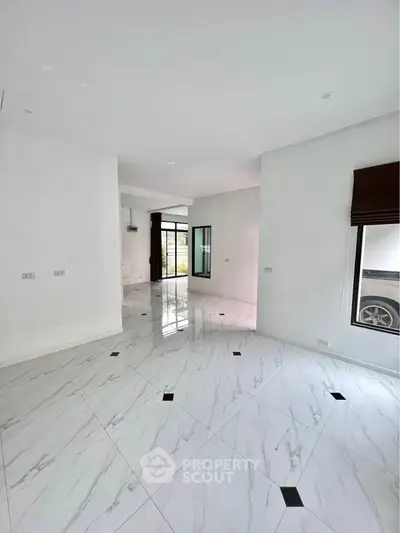Spacious modern living room with elegant marble flooring and large windows for natural light.