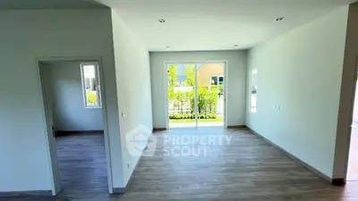 Spacious modern living room with large windows and wooden flooring