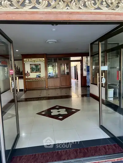Elegant building entrance with glass doors and decorative interior design