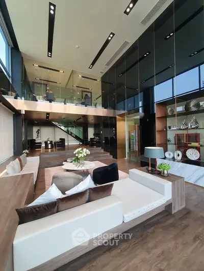 Luxurious modern living room with high ceilings and elegant decor in a spacious open-plan design.