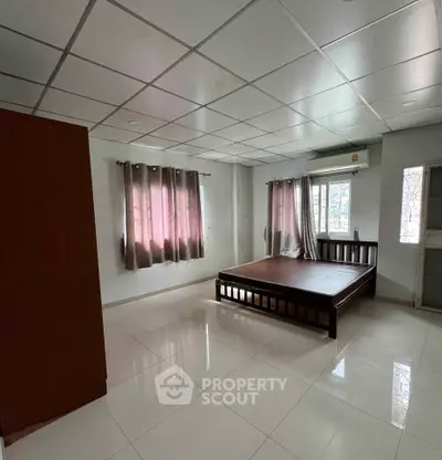 Spacious bedroom with large windows and modern tile flooring