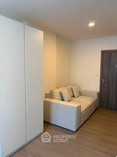 Modern living room with cozy sofa and sleek wooden flooring in a stylish apartment.