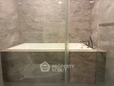 Luxurious marble bathroom with modern bathtub and sleek fixtures, perfect for relaxation and elegance.