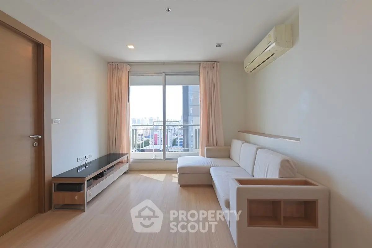 Modern living room with city view, featuring sleek furniture and natural light.