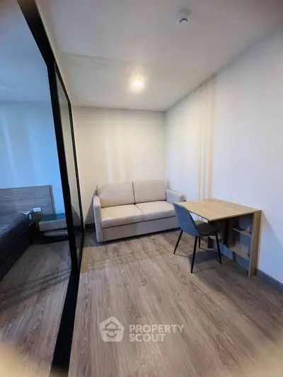 Modern compact living room with sofa and study desk, ideal for urban living.