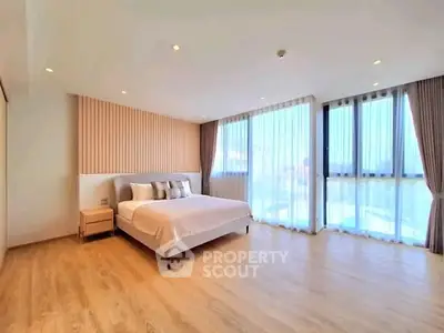 Spacious modern bedroom with large windows and elegant decor