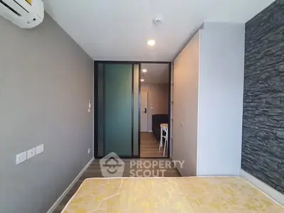 Modern bedroom with stylish decor and sliding glass door in a contemporary apartment.