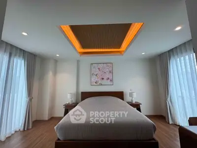 Elegant bedroom with modern lighting and large windows for natural light.