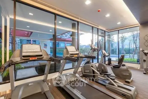 Modern gym with treadmills and exercise bikes in a luxury residential building.