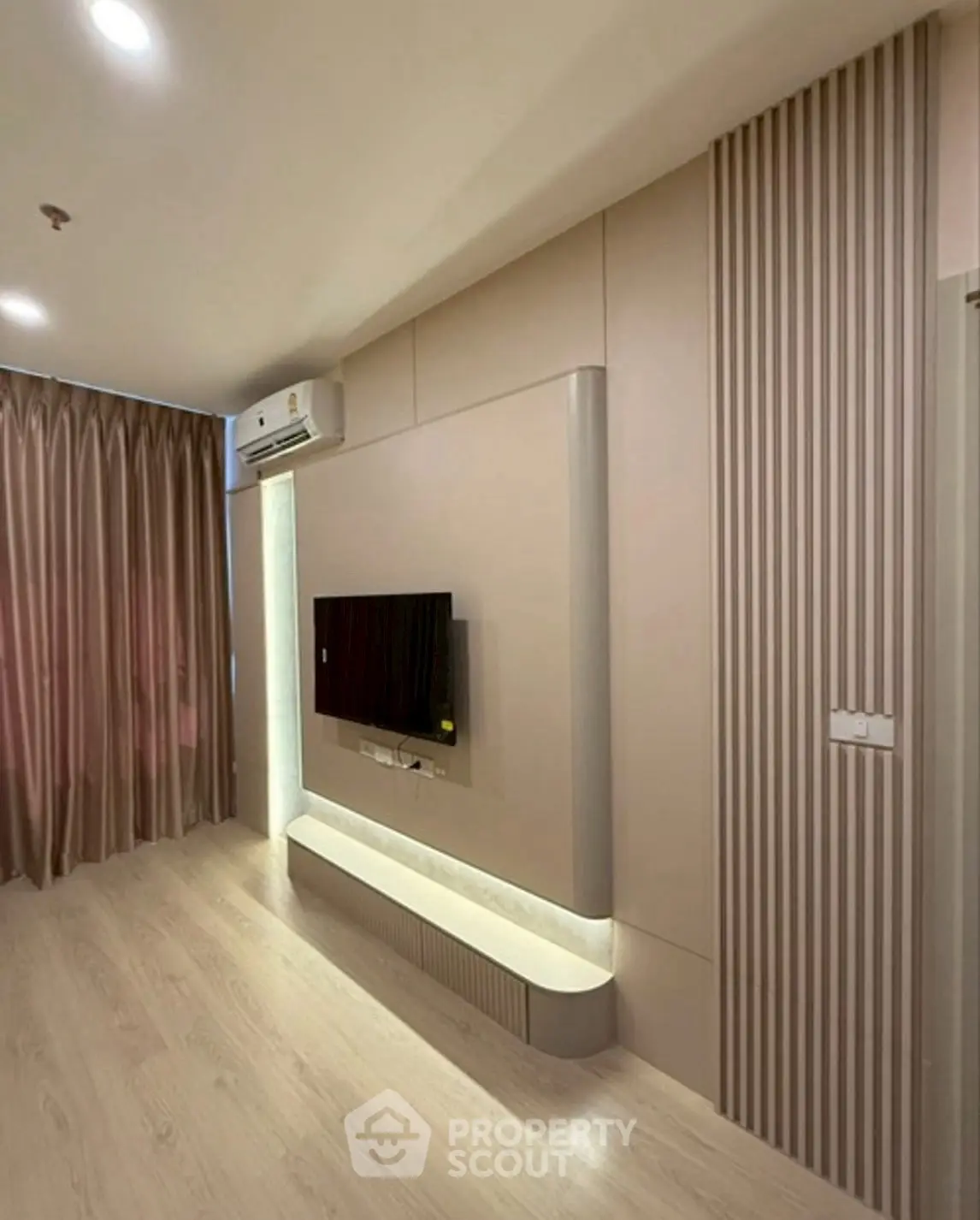 Modern living room with sleek TV setup and elegant curtains