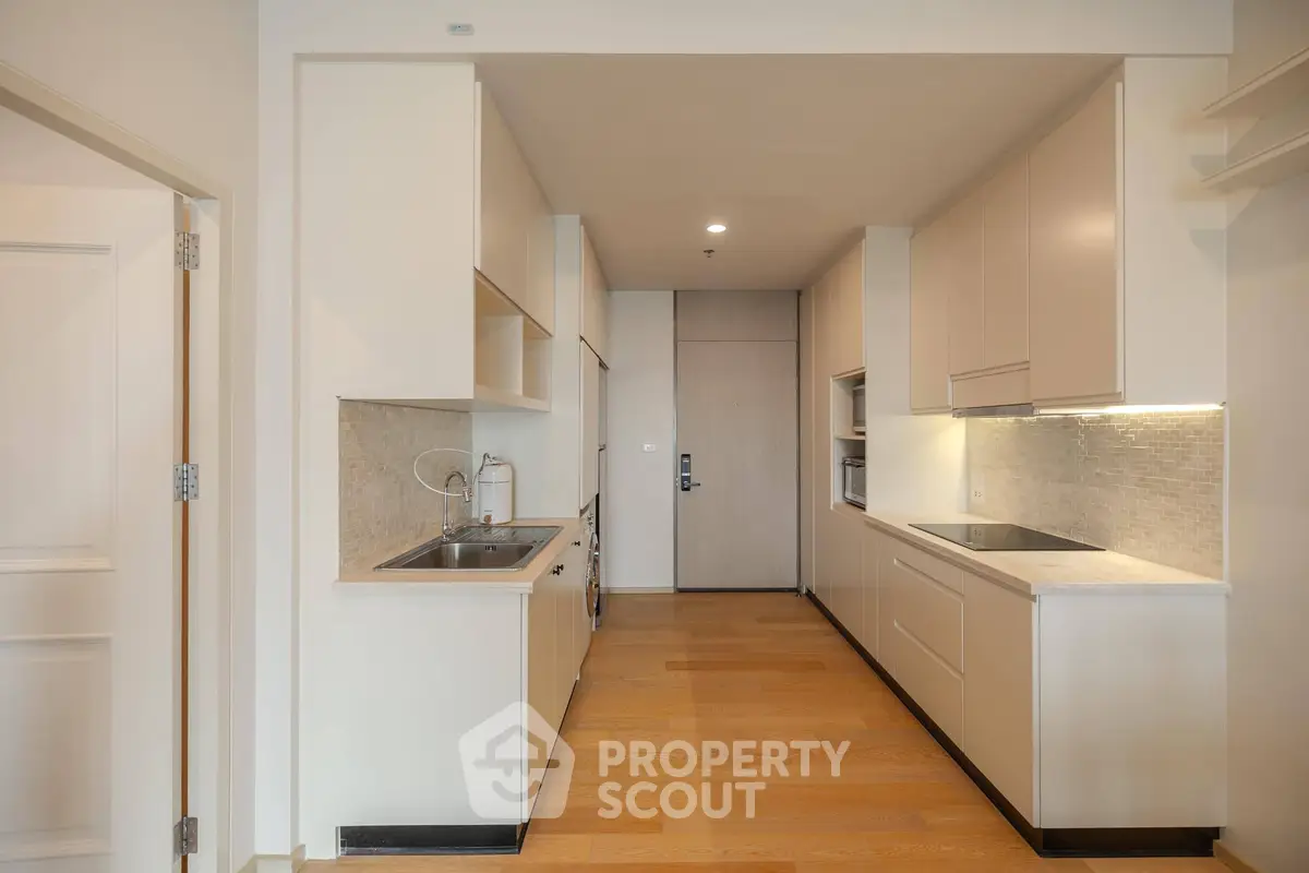 Modern kitchen with sleek cabinetry and hardwood floors in a contemporary apartment.