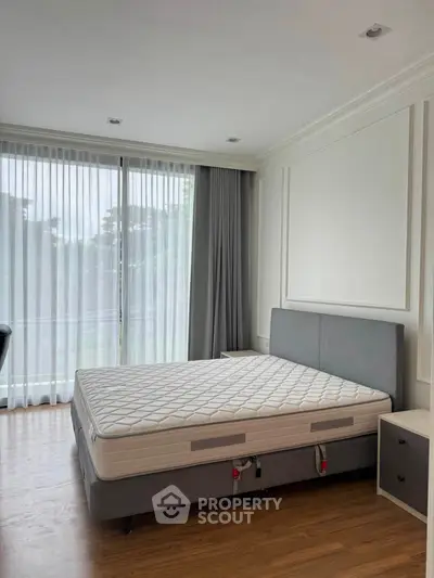 Spacious bedroom with large windows and modern decor, perfect for natural light lovers.