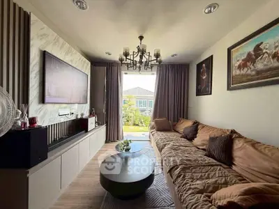 Luxurious living room with elegant decor and garden view, featuring plush seating and modern chandelier.