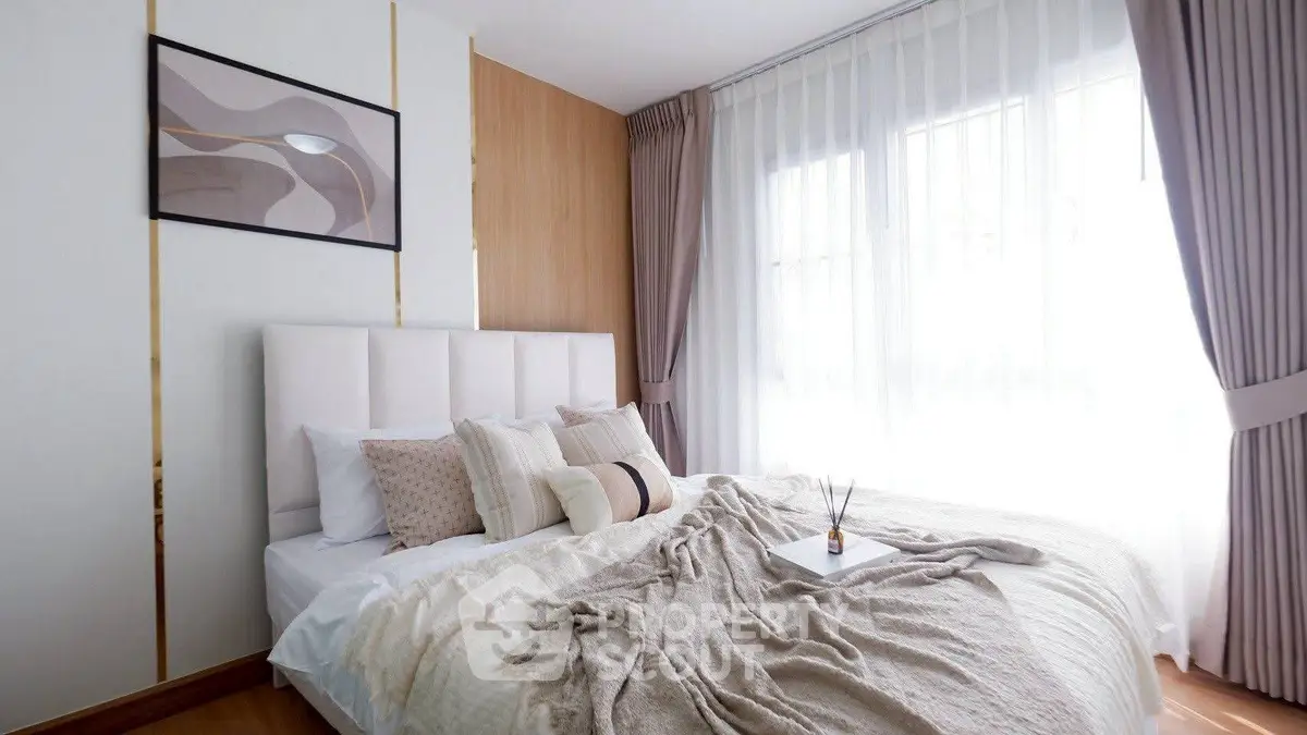 Elegant bedroom with modern decor and natural light, featuring cozy bedding and stylish curtains.