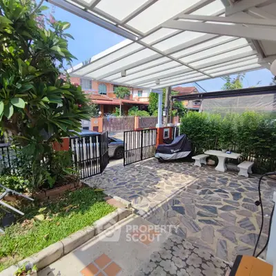 Charming residential garden with paved patio and lush greenery, perfect for outdoor relaxation.