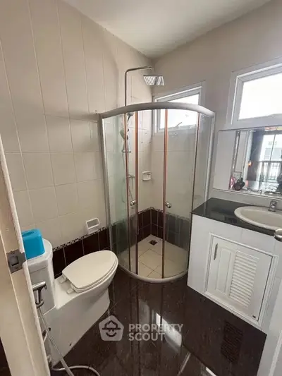 Modern bathroom with glass shower and sleek vanity in contemporary home.