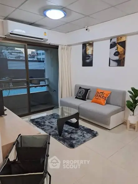 Modern living room with stylish decor and balcony access in urban apartment.