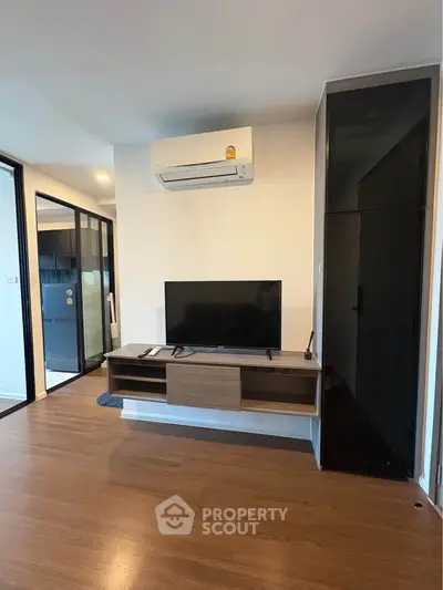Modern living room with sleek TV stand and air conditioning in a stylish apartment.