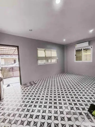 Spacious room with patterned tile flooring and large windows in modern home.