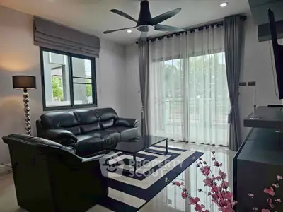 Modern living room with black leather sofas and stylish decor