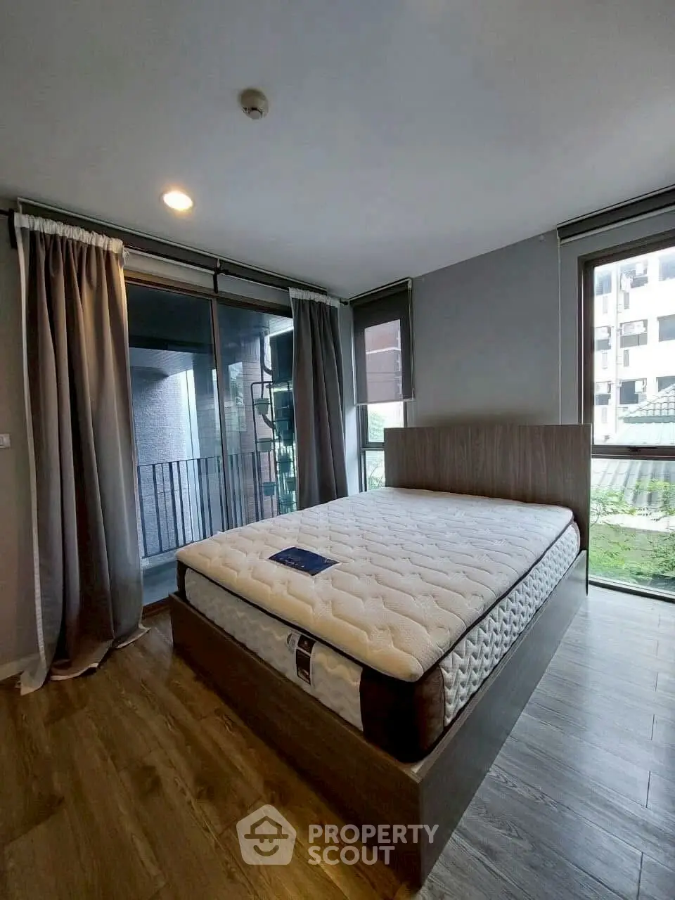 Spacious bedroom with large windows and modern decor in a stylish apartment.