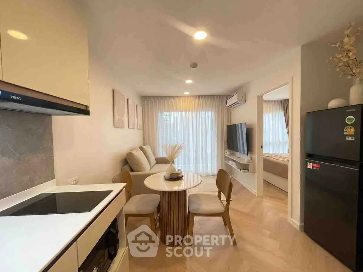 Modern open-plan living room and kitchen with stylish decor and natural light.