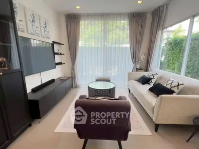 Elegant living room with modern decor, large windows, and cozy seating area.