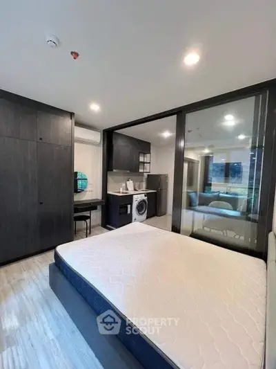 Modern studio apartment with sleek design and integrated kitchen appliances