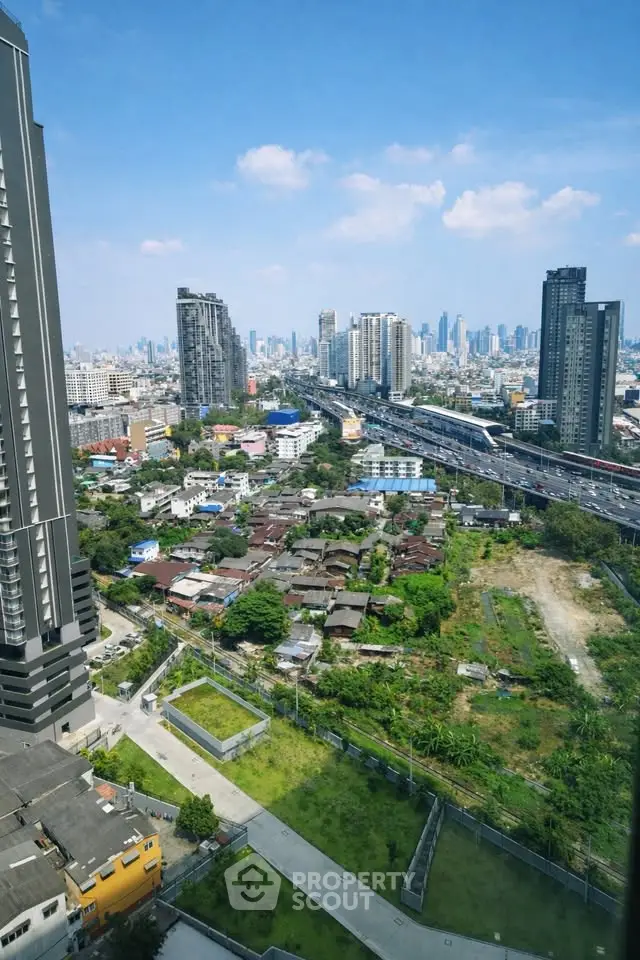 Stunning cityscape view from high-rise building with lush greenery and urban skyline.