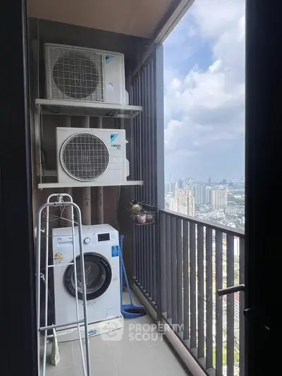 High-rise balcony with city view, featuring washing machine and air conditioning units.