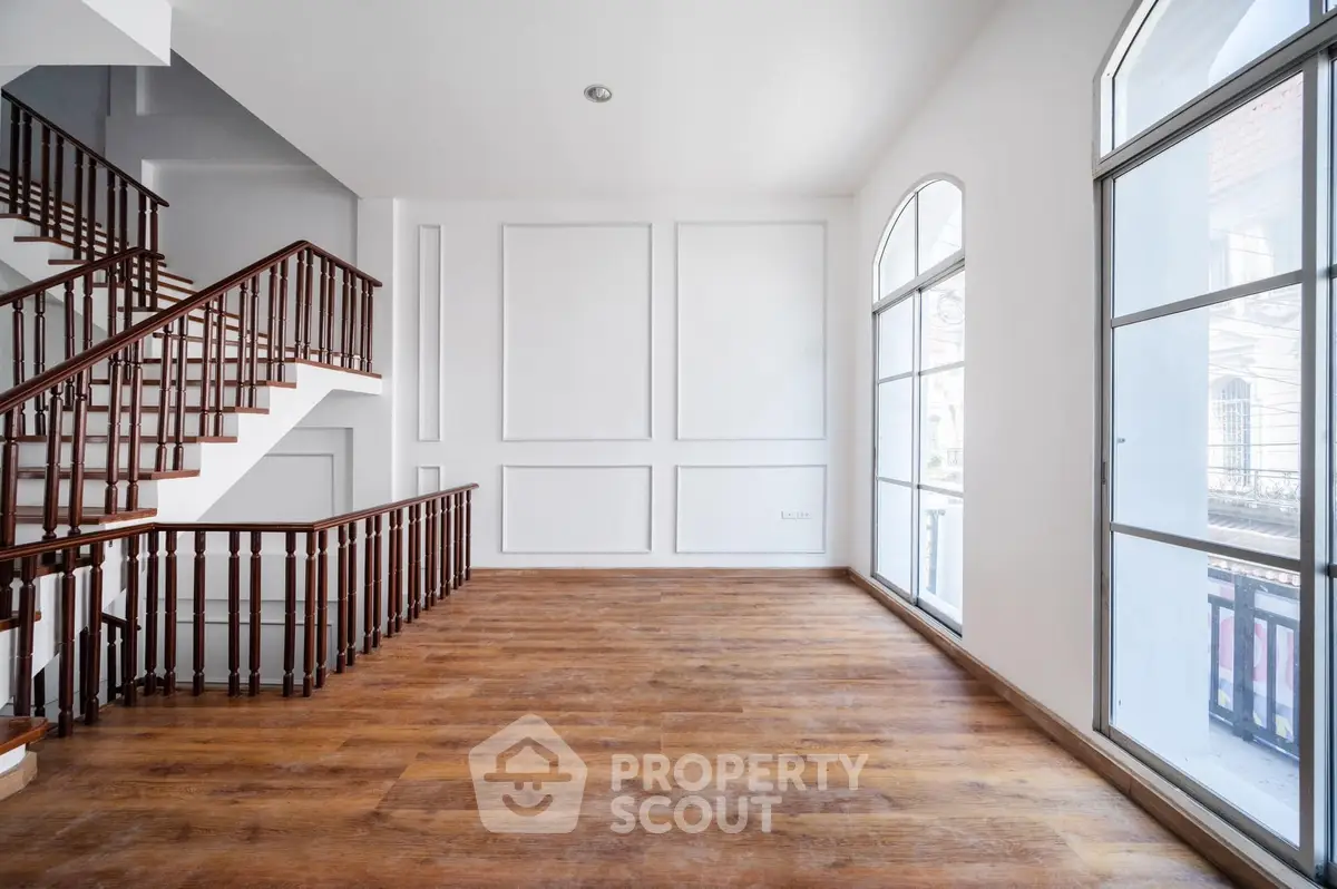 Spacious interior with elegant staircase and large windows, perfect for modern living.
