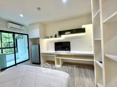 Modern bedroom with built-in desk and large window overlooking greenery, featuring sleek design and ample storage.