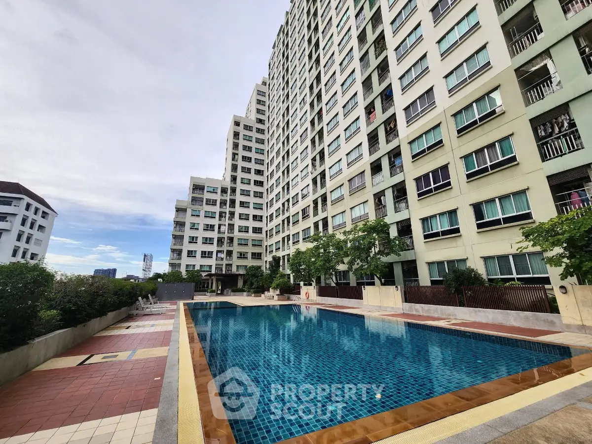 Spacious residential building with a pristine swimming pool and lush greenery, perfect for modern living.