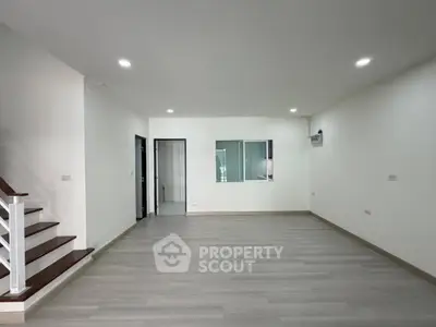 Spacious modern living room with sleek flooring and recessed lighting, perfect for contemporary living.