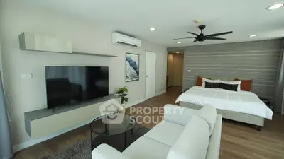 Modern studio apartment with stylish decor, featuring a cozy living area and comfortable bed.