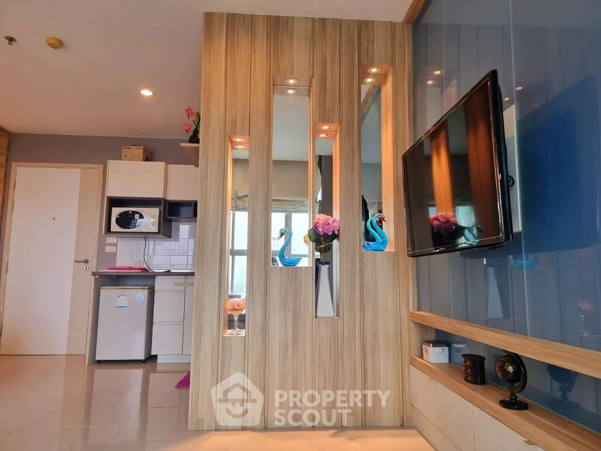 Modern living room with stylish decor and wall-mounted TV in a cozy apartment.