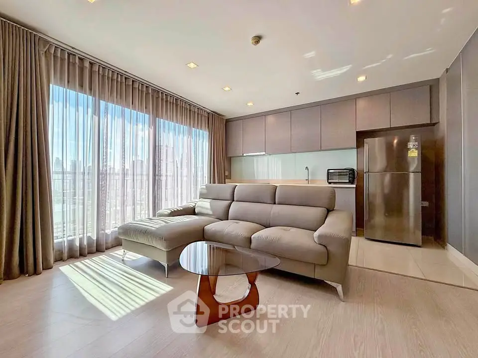 Spacious modern living room with large windows and sleek kitchen in luxury apartment.