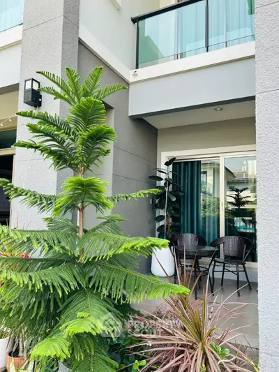 Modern balcony with stylish furniture and lush greenery in a contemporary building