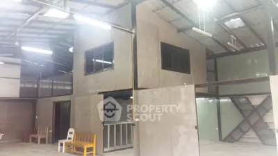 Spacious industrial-style interior with high ceilings and modern design.