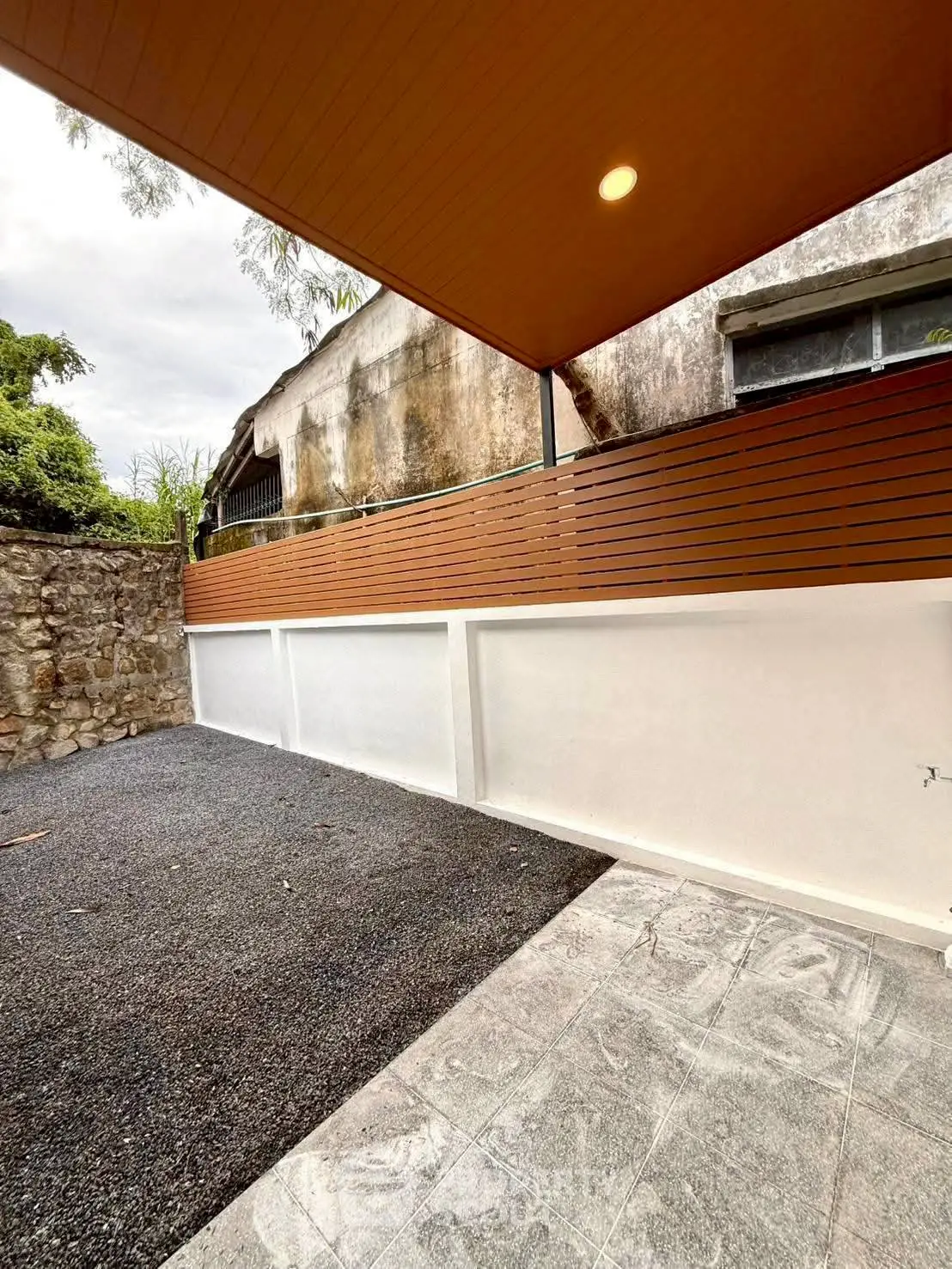 Spacious outdoor area with modern wooden fencing and stone flooring, perfect for relaxation and gatherings.